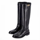 Stivale in pelle nera stile cavallerizzo tubolare con cinturino giro polpaccio chiuso da fibbia metallica color oro.