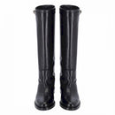 Stivale in pelle nera stile cavallerizzo tubolare con cinturino giro polpaccio chiuso da fibbia metallica color oro.