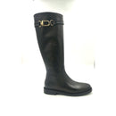 Stivale in pelle nera stile cavallerizzo con cinturino giro polpaccio chiuso da fibbia metallica color oro.